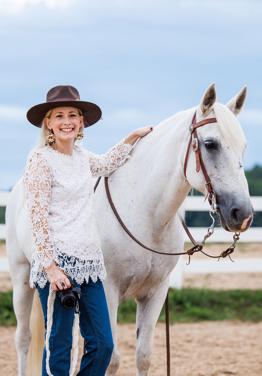 Jamie standing with horse wearing brown hat