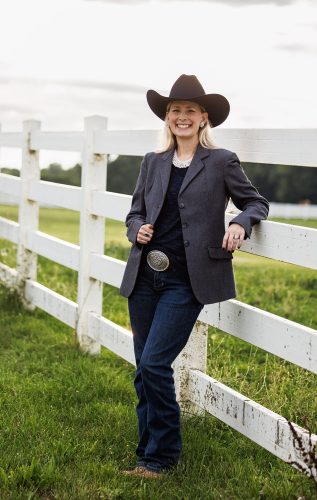 Suit-Jacket-against-fence Jamie in a dark blazer leaning on a white fence